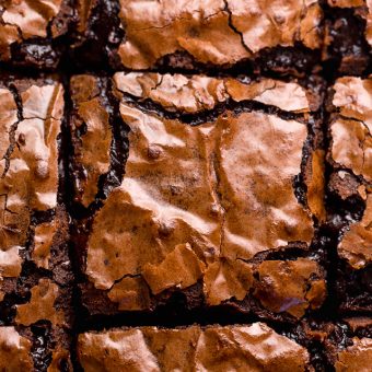 Homemade brownies in prepared baking pan, sliced into squares.