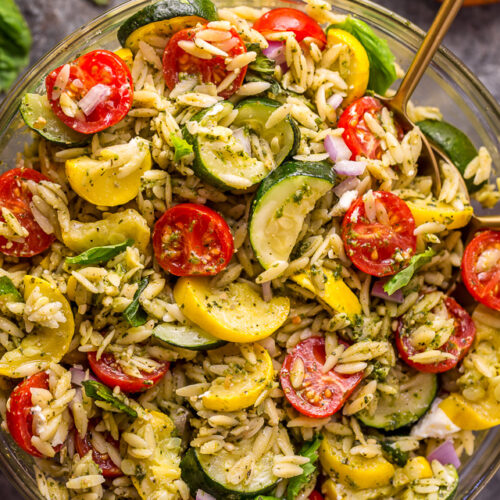 It's beginning to feel a lot like Summer, and you know what that means, right? It's PASTA SALAD SEASON! And this Pesto Orzo Pasta Salad with Zucchini, Goat Cheese, and Tomatoes is sure to be on heavy rotation all Summer long! This mayo-free pasta salad is vegetarian friendly and perfect for picnics, potlucks, and barbecues! #pestopastasalad #pesto #orzo #orzopastasalad