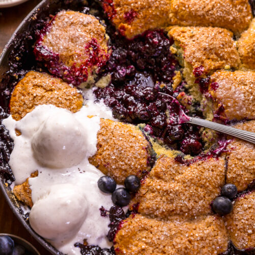 When blueberries go on sale, stock up so you can make this quick and easy blueberry cobbler recipe! Featuring the juiciest blueberry filling and a buttery biscuit topping, this Summer dessert is so good with a scoop of vanilla ice cream on top! While I always prefer to use fresh fruit, this recipe will work with fresh or frozen blueberries! #blueberrycobbler