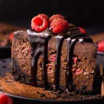 This Dark Chocolate Raspberry Cheesecake is pure decadence! It's not too sweet and but very rich, so a small slice goes far! The fresh raspberry pockets swirled throughout are delightfully refreshing! #chocolateraspberrycheesecake #chocolate #raspberry #raspberrycheesecake #cheesecake #Chocolatecheesecake #dessertrecipes