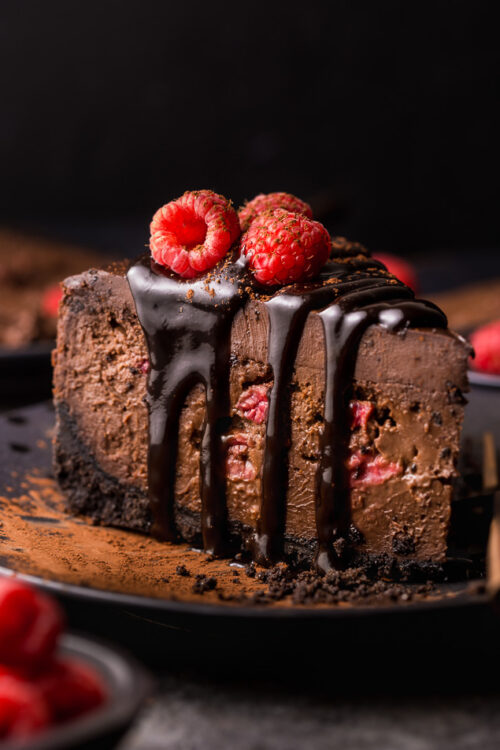 This Dark Chocolate Raspberry Cheesecake is pure decadence! It's not too sweet and but very rich, so a small slice goes far! The fresh raspberry pockets swirled throughout are delightfully refreshing! #chocolateraspberrycheesecake #chocolate #raspberry #raspberrycheesecake #cheesecake #Chocolatecheesecake #dessertrecipes