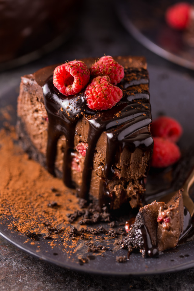 This Dark Chocolate Raspberry Cheesecake is pure decadence! It's not too sweet and but very rich, so a small slice goes far! The fresh raspberry pockets swirled throughout are delightfully refreshing! #chocolateraspberrycheesecake #chocolate #raspberry #raspberrycheesecake #cheesecake #Chocolatecheesecake #dessertrecipes 