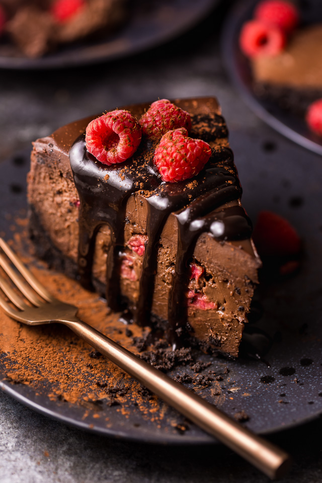 This Dark Chocolate Raspberry Cheesecake is pure decadence! It's not too sweet and but very rich, so a small slice goes far! The fresh raspberry pockets swirled throughout are delightfully refreshing! #chocolateraspberrycheesecake #chocolate #raspberry #raspberrycheesecake #cheesecake #Chocolatecheesecake #dessertrecipes 