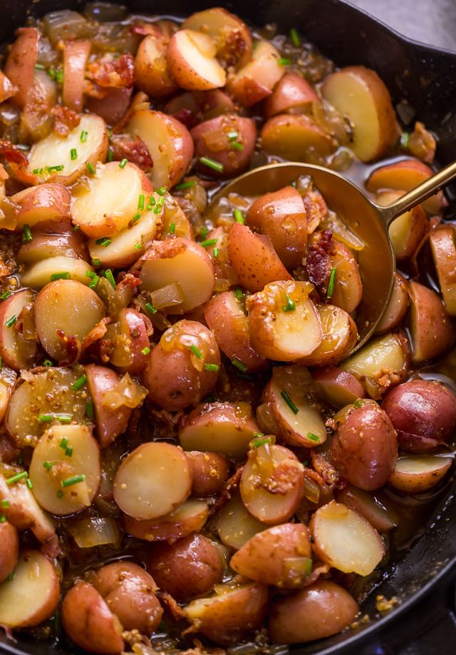 I had my first taste of German Potato Salad 7 years ago and it was love at first bite! It's made with baby red potatoes, yellow onion, and an apple cider vinegar dressing consisting of salt, pepper, mustard, and sugar. And then it's topped with cooked bacon, chopped chives, and a drizzle of olive oil! This potato salad is served warm and makes a great side dish! #potatosalad #Germanpotatosalad 