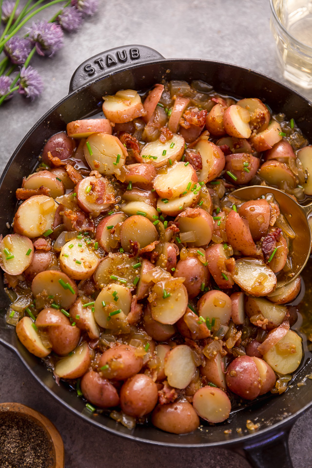 I had my first taste of German Potato Salad 7 years ago and it was love at first bite! It's made with baby red potatoes, yellow onion, and an apple cider vinegar dressing consisting of salt, pepper, mustard, and sugar. And then it's topped with cooked bacon, chopped chives, and a drizzle of olive oil! This potato salad is served warm and makes a great side dish! #potatosalad #Germanpotatosalad 