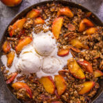 In my humble opinion, the only thing better than peach crisp is BOURBON PECAN PEACH CRISP! Made with brown sugar, fresh peaches, bourbon, and a touch of cinnamon, this is Summer in a baking dish! Serve warm while the fruit is bubbling, with a big scoop of vanilla ice cream on top! #peachcrisp #bourbonpecan #bourbonpeachpie #peaches #peachrecipes