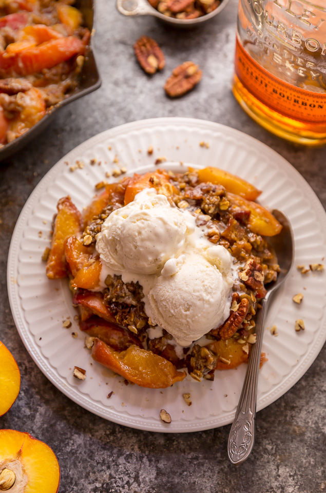In my humble opinion, the only thing better than peach crisp is BOURBON PECAN PEACH CRISP! Made with brown sugar, fresh peaches, bourbon, and a touch of cinnamon, this is Summer in a baking dish! Serve warm while the fruit is bubbling, with a big scoop of vanilla ice cream on top! #peachcrisp #bourbonpecan #bourbonpeachpie #peaches #peachrecipes