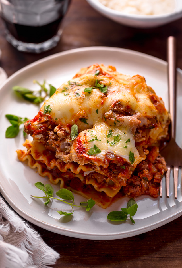 The Best Homemade Lasagna Recipe is cheesy, meaty, saucy, and SO delicious!!! And while this recipe requires a bit of work, it can be made ahead of time and stored in the fridge for up to 24 hours before baking. A hearty recipe that's perfect for feeding large groups! #lasagna #lasagnarecipe 