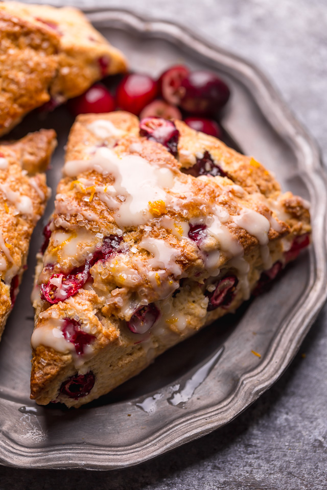 Cranberry Orange Scones are loaded with vibrant orange flavor, fresh cranberries, and topped with a sweet orange glaze! These are so festive and perfect for breakfast or brunch. And one of my favorite scone recipes to make during the holiday season!