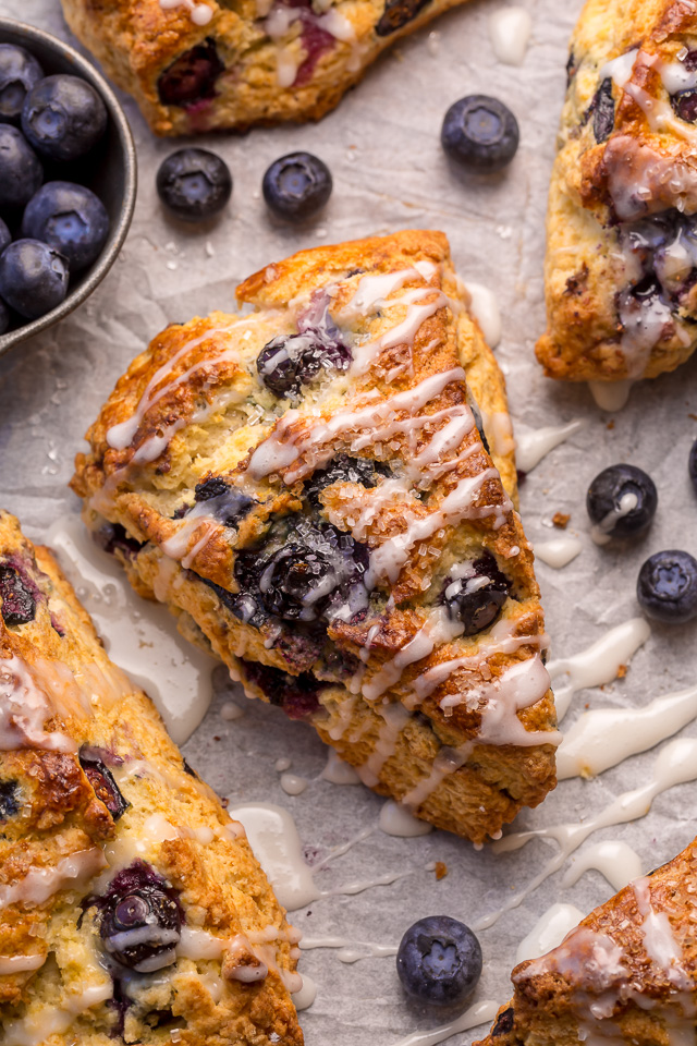 These Classic Bakery-Style Blueberry Scones are sweet, buttery, and exploding with fresh blueberries! Topped with sparkling coarse sugar and a sweet vanilla glaze, these are perfect for breakfast or brunch! Even scone haters love this recipe!