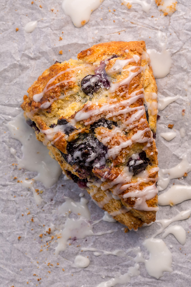 These Classic Bakery-Style Blueberry Scones are sweet, buttery, and exploding with fresh blueberries! Topped with sparkling coarse sugar and a sweet vanilla glaze, these are perfect for breakfast or brunch! Even scone haters love this recipe!