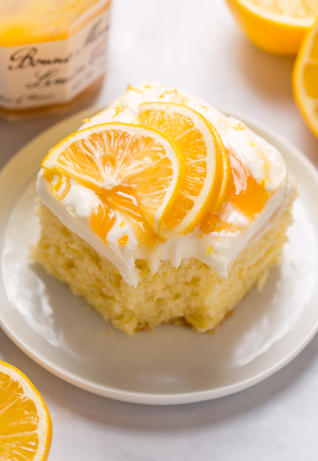 My lemon cake for a crowd is moist, fluffy, and loaded with fresh lemon flavor! Topped with silky smooth lemon cream cheese frosting, dollops of lemon curd, and fresh lemon slices, this is one of my most popular lemon desserts. Bonus: this lemon sheet cake is so easy and feeds a crowd!