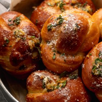 Soft Pretzel Garlic Knots are chewy, flavorful, and so delicious! Made with a simple soft pretzel dough, they're shaped like knots and baked until golden brown. Then topped with garlic butter and parmesan cheese!