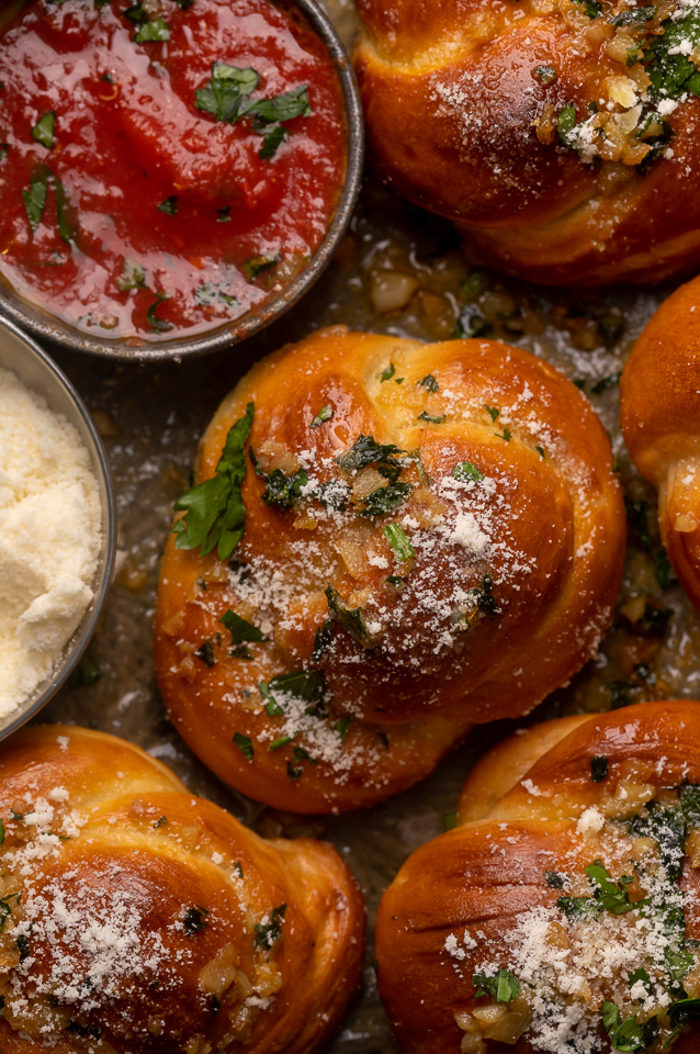 Soft Pretzel Garlic Knots are chewy, flavorful, and so delicious! Made with a simple soft pretzel dough, they're shaped like knots and baked until golden brown. Then topped with garlic butter and parmesan cheese!