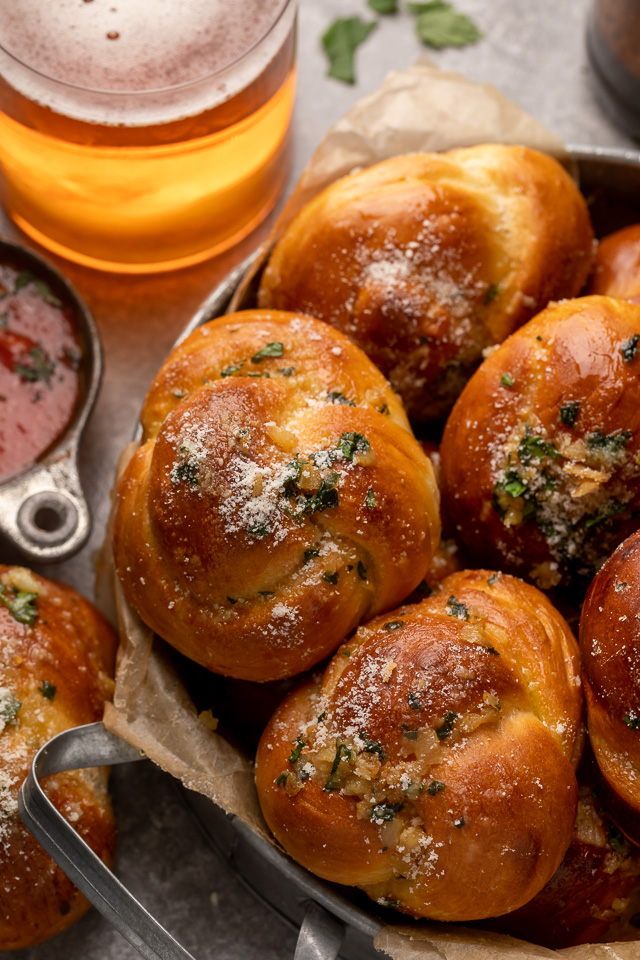 Soft Pretzel Garlic Knots are chewy, flavorful, and so delicious! Made with a simple soft pretzel dough, they're shaped like knots and baked until golden brown. Then topped with garlic butter and parmesan cheese!