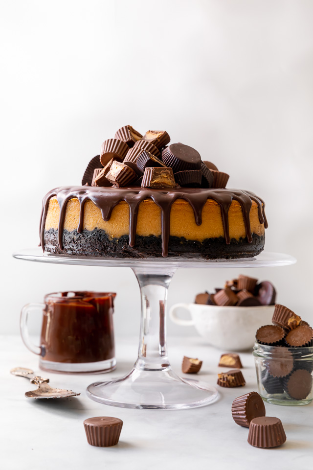 This Chocolate Covered Peanut Butter Cheesecake is ultra creamy and the perfect marriage of chocolate and peanut butter! Featuring an oreo crust, creamy peanut butter cheesecake filling, and topped with with peanut butter chocolate ganache and peanut butter cups, it's a true showstopper! And any leftovers freeze great!