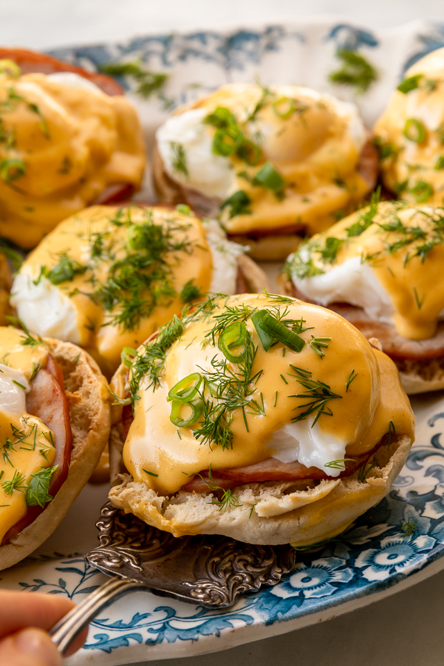 Featuring golden brown toasted English muffins, poached eggs, slices of Canadian bacon, and hollandaise sauce, this Eggs Benedict recipe is pure perfection! Top with freshly chopped dill and scallions, or simply serve with salt and pepper. Perfect for any special at-home breakfast or brunch!