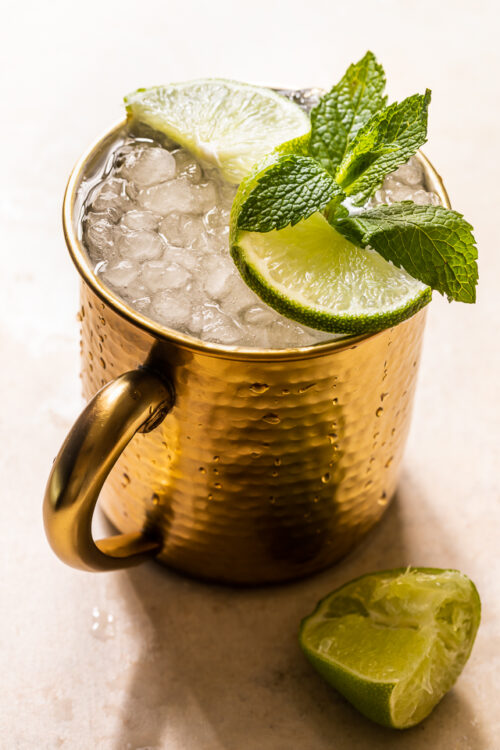 The Best Moscow Mule Recipe features spicy ginger beer, fresh lime juice, vodka, and a ginger lime simple syrup! On a hot Summer day, this refreshing cocktail really hits the spot! For an extra pretty presentation, serve in a copper mug with a sprig of mint and a lime wedge or spiral!