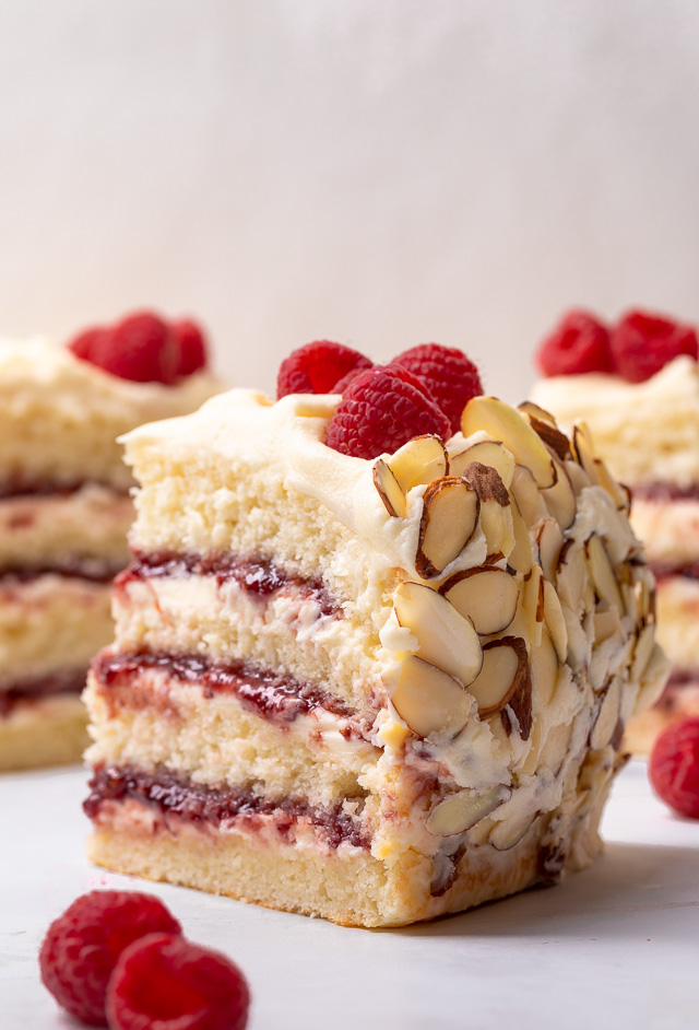 This Almond Raspberry Cake with White Chocolate Amaretto Buttercream Frosting is a total showstopper! Featuring four layers of light and fluffy almond cake, raspberry filling, and creamy white chocolate amaretto cream, this cake is decadently sweet! A must try if you love raspberry almond desserts!