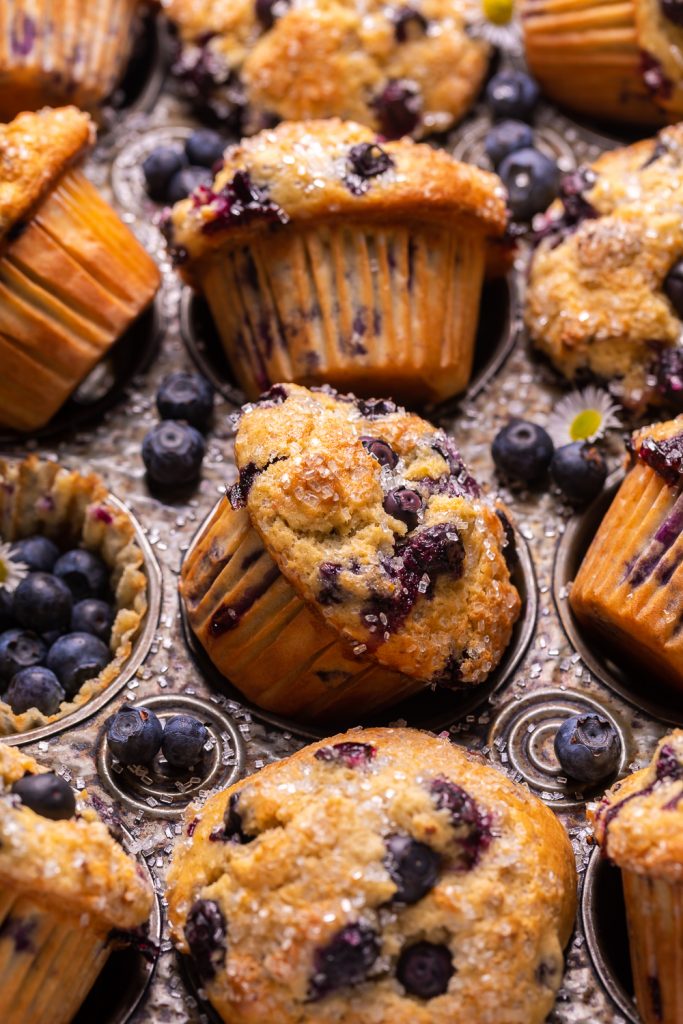 Muffins in muffin tin with blueberries on top.