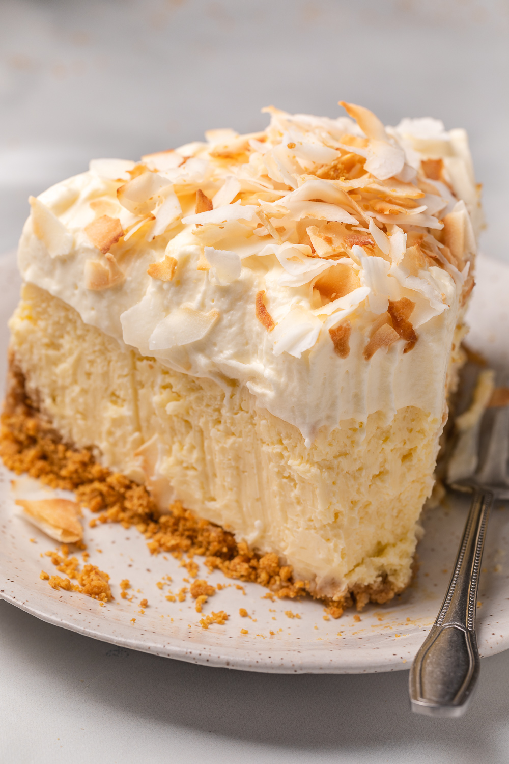 This Creamy Coconut Cheesecake is made with coconut milk, coconut extract, and shredded coconut, so you know it's loaded with refreshing coconut flavor! The crunchy graham cracker crust is the perfect contrast to the creamy filling and fluffy whipped cream topping. A must try for coconut lovers!