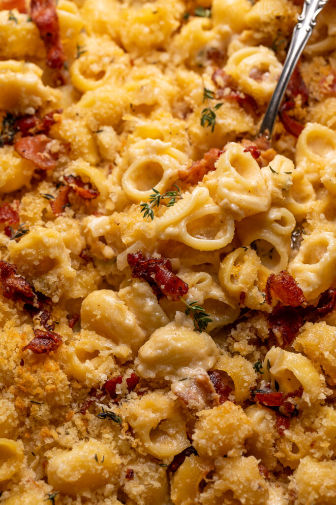 Baking dish with backed macaroni and cheese being scooped out.