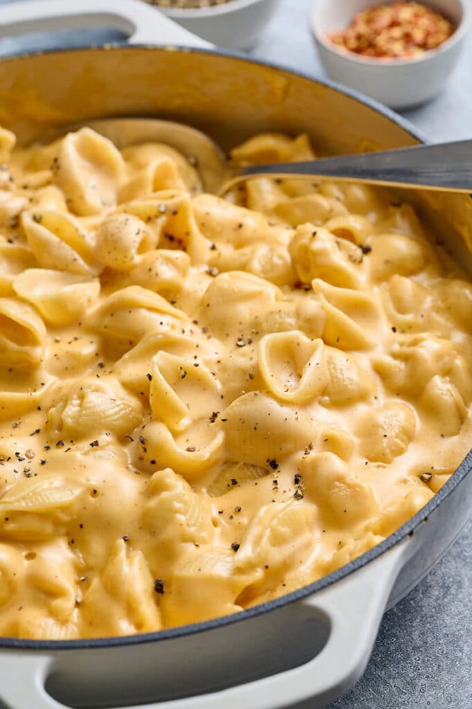 Mac and cheese in a skillet with black pepper on top.