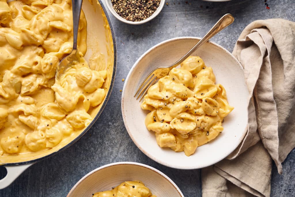 Macaroni and cheese spooned into serving bowls. 