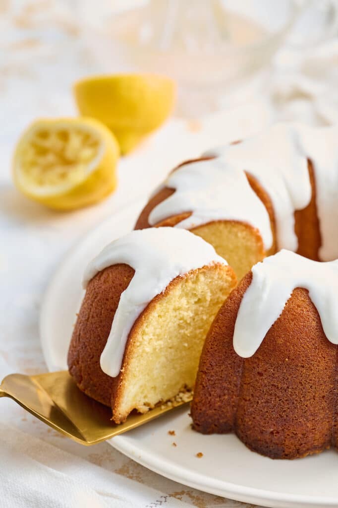 Lemon bundt cake with piece being removed from the cake.