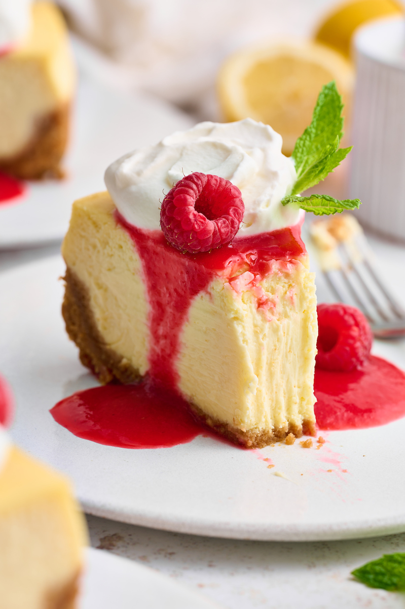 This stunning lemon ginger cheesecake is rich, cream, and silky smooth! Made with fresh ginger, lemon juice, and lemon zest, it's bursting with fresh flavor. The hot pink raspberry sauce makes it a total showstopper!
