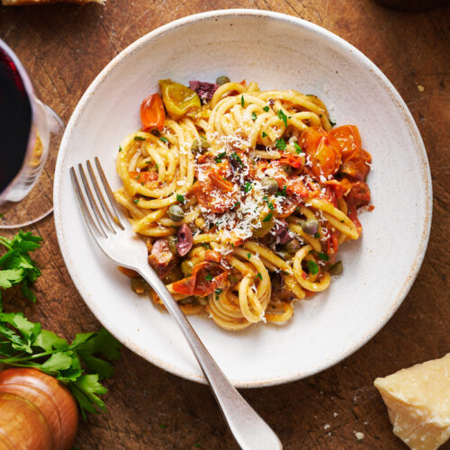 If you're looking for some dinner inspiration, allow me to tempt you with this fresh tomato pasta puttanesca. The tomato based puttanesca sauce is made from pantry staples like anchovy fillets, capers, and black olives. And it gets tossed with al dente pasta (any variety will work) for a classic Italian pasta dish the whole family will enjoy!