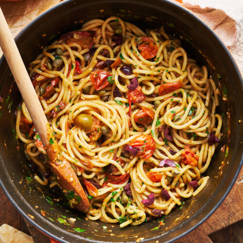 If you're looking for some dinner inspiration, allow me to tempt you with this fresh tomato pasta puttanesca. The tomato based puttanesca sauce is made from pantry staples like anchovy fillets, capers, and black olives. And it gets tossed with al dente pasta (any variety will work) for a classic Italian pasta dish the whole family will enjoy!