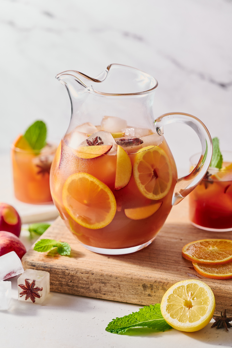 If you're searching for a big batch summer cocktail, look no further than this bourbon spiked peach iced tea! Made with peach nectar, black tea, and fresh peach slices, this recipe is perfect for barbecues, parties, and picnics. Bust out a large pitcher and make a batch today!