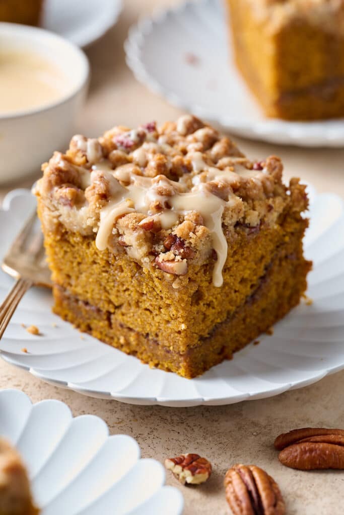 Slice of pumpkin coffee cake with maple glaze on a plate.