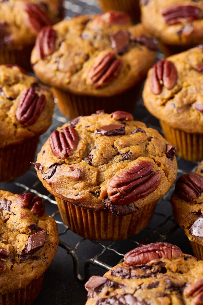 Pumpkin chocolate chip muffins on a wire rack. 