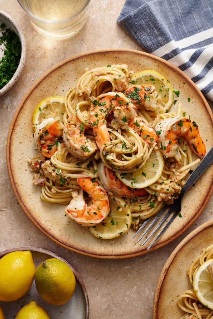 Learn how to cook shrimp scampi in 20 minutes with this easy shrimp scampi recipe! Juicy shrimp are cooked in garlic butter, white wine, and lemon juice creating the most delicious shrimp scampi sauce ever! Sprinkled with fresh parsley and red pepper flakes. We love serving this with pasta (we love linguini or angel hair), zucchini noodles, crusty bread, and dry white wine.