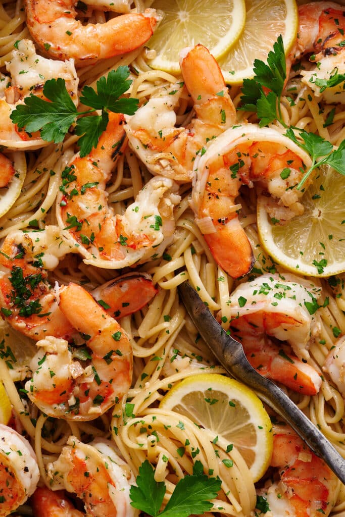 Learn how to cook shrimp scampi in 20 minutes with this easy shrimp scampi recipe! Juicy shrimp are cooked in garlic butter, white wine, and lemon juice creating the most delicious shrimp scampi sauce ever! Sprinkled with fresh parsley and red pepper flakes. We love serving this with pasta (we love linguini or angel hair), zucchini noodles, crusty bread, and dry white wine.