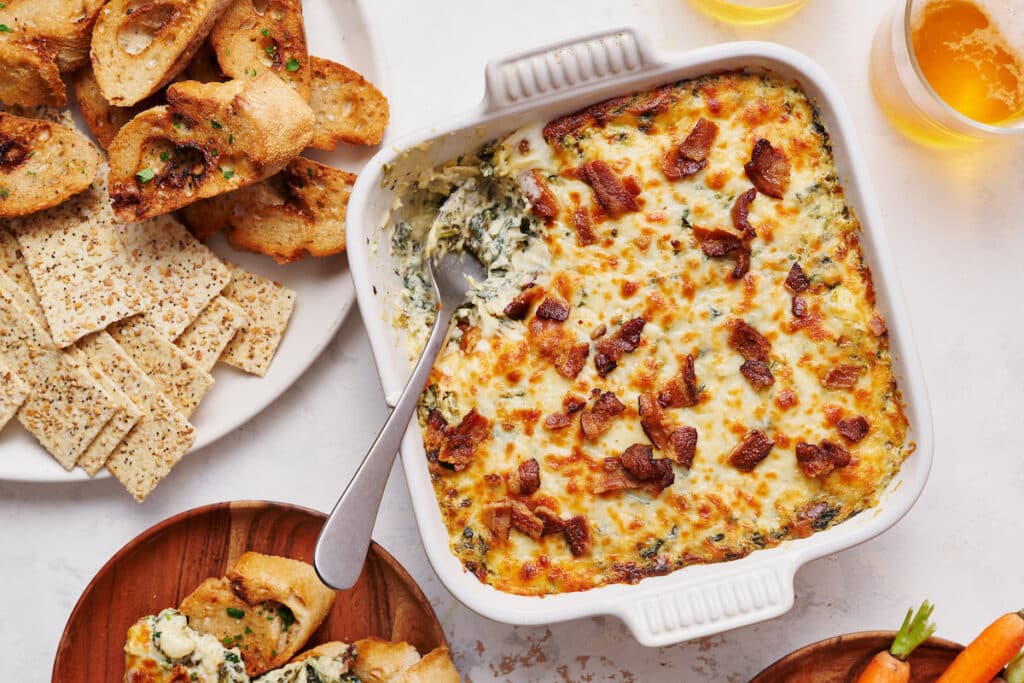 Hot spinach artichoke dip served with tortilla chips, crackers, and baguette. 

