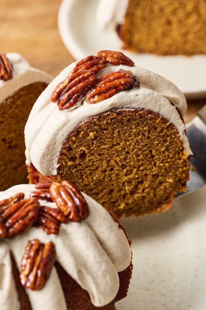 Slice of pumpkin bundt cake being removed from cake.