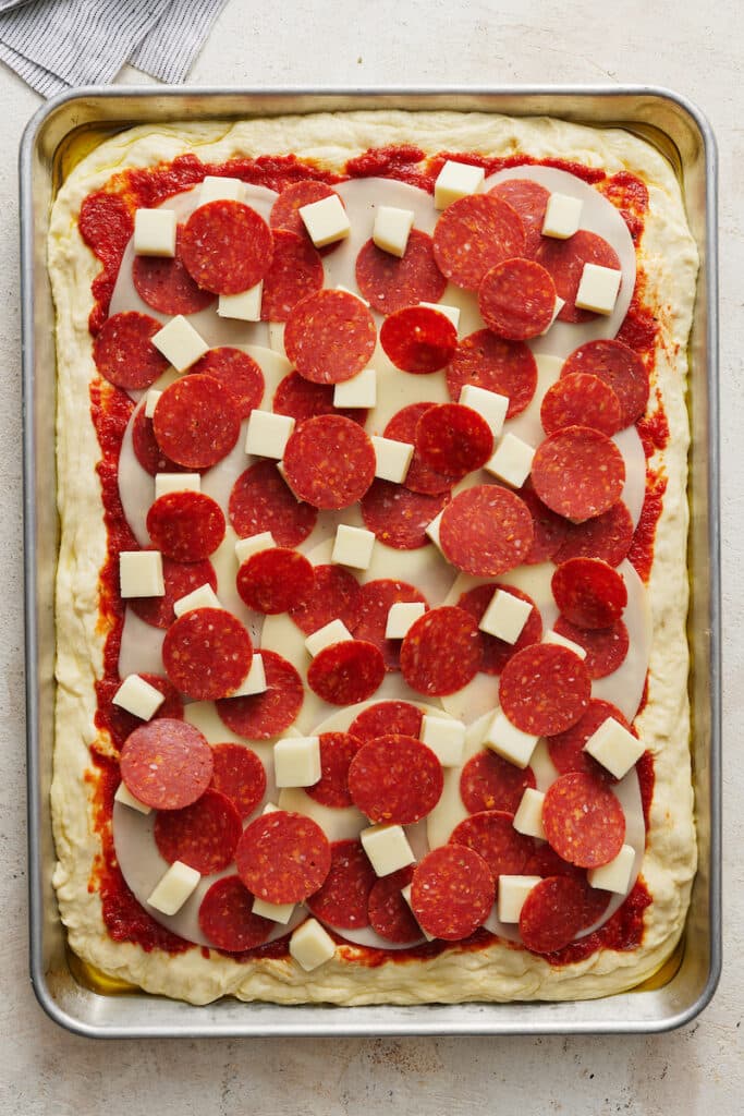 Pepperoni pizza in pizza pan ready to be baked. 