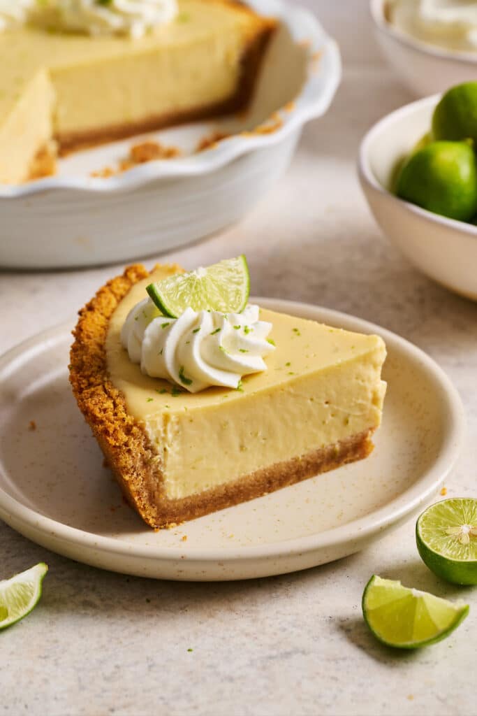 Slice of key lime pie on pie plate.