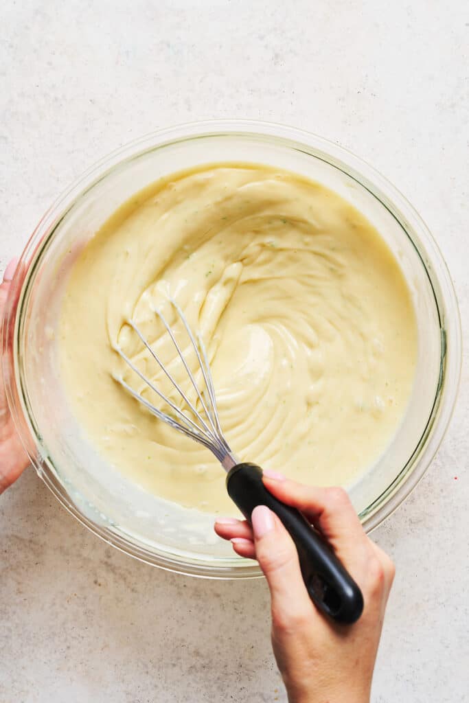 Key lime pie filling being whisked together in mixing bowl.