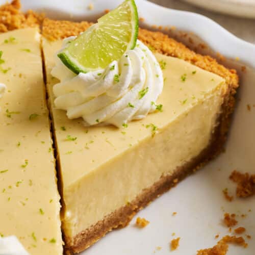 Slice of key lime pie in pie plate.