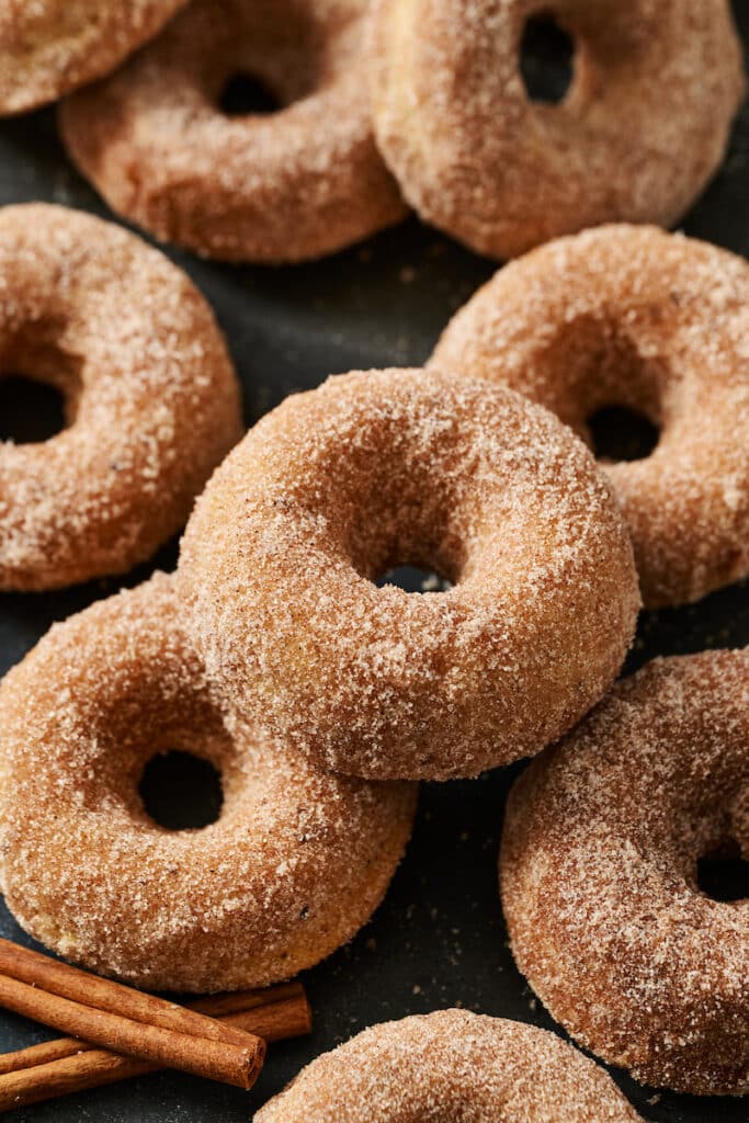 Cinnamon sugar donuts on a tray with a bite taken out.