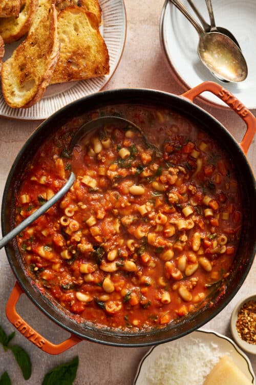 Dutch oven full of pasta fagioli soup with ladle.