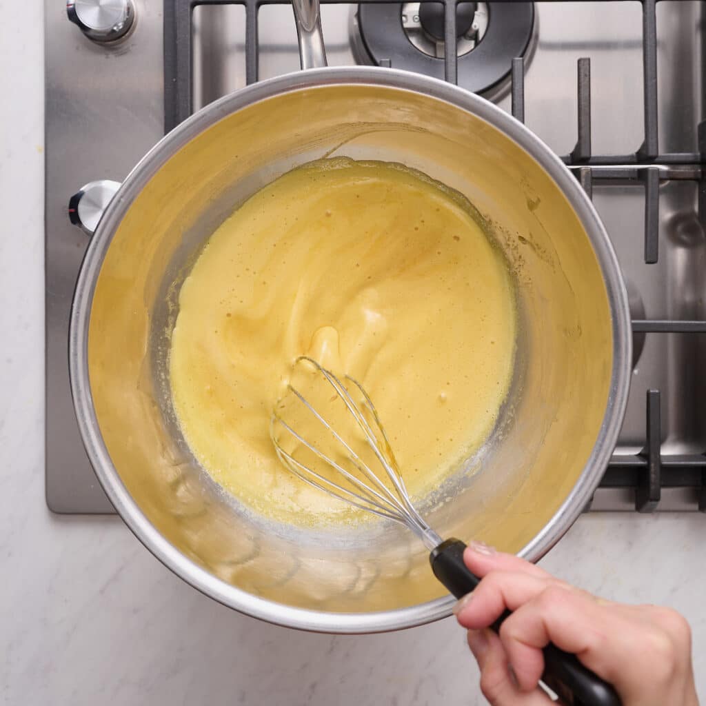 Egg yolks, sugar, and amaretto in a double boiler.