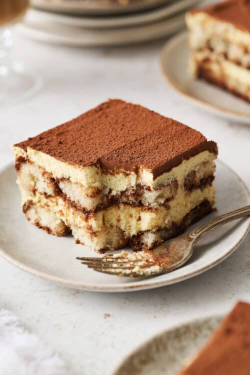 Slice of tiramisu on a white dessert plate.