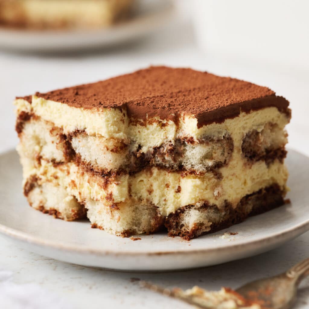 Slice of tiramisu on a white plate.