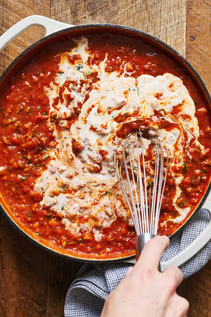 A large pot of bolognese sauce tossed with pasta.