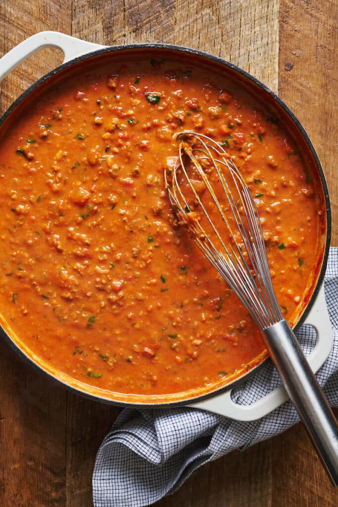 A large pot of bolognese sauce tossed with pasta.